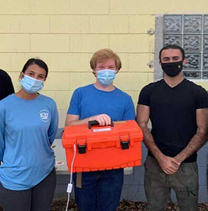 To help with SALT's sustainability efforts, Moses Hinrichsen (center) and the engineers of UCF's Next Gen Engineering created a UV device that sanitizes masks for reuse.